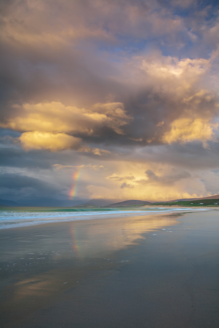  a beach with a rainbow in the sky