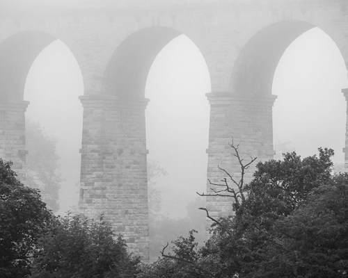 Crimple Valley Viaduct: A Marvel of Engineering and Beauty: Distant view of Crimple Viaduct through fog a view of a tall building