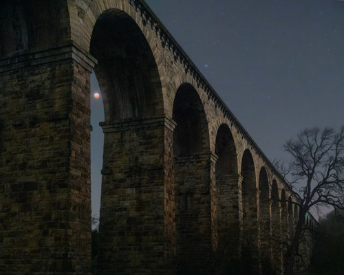 Nightscapes:  a large stone building with a bridge in the background