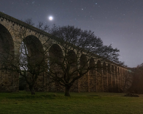 Nightscapes:  a bridge over a large green field