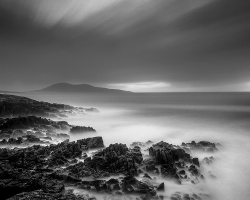 Seascapes of the Outer Hebrides:  a rocky landscape with a body of water in the distance