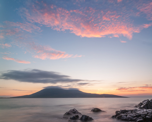 Seascapes of the Outer Hebrides:  a body of water with rocks and a mountain in the background