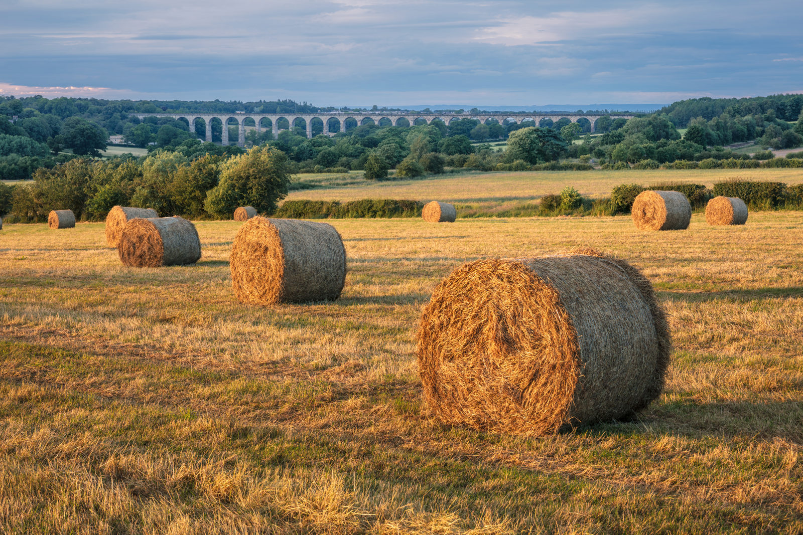 Bales of hay in the Crimple Valley with the Crimple Viaduct in the distance