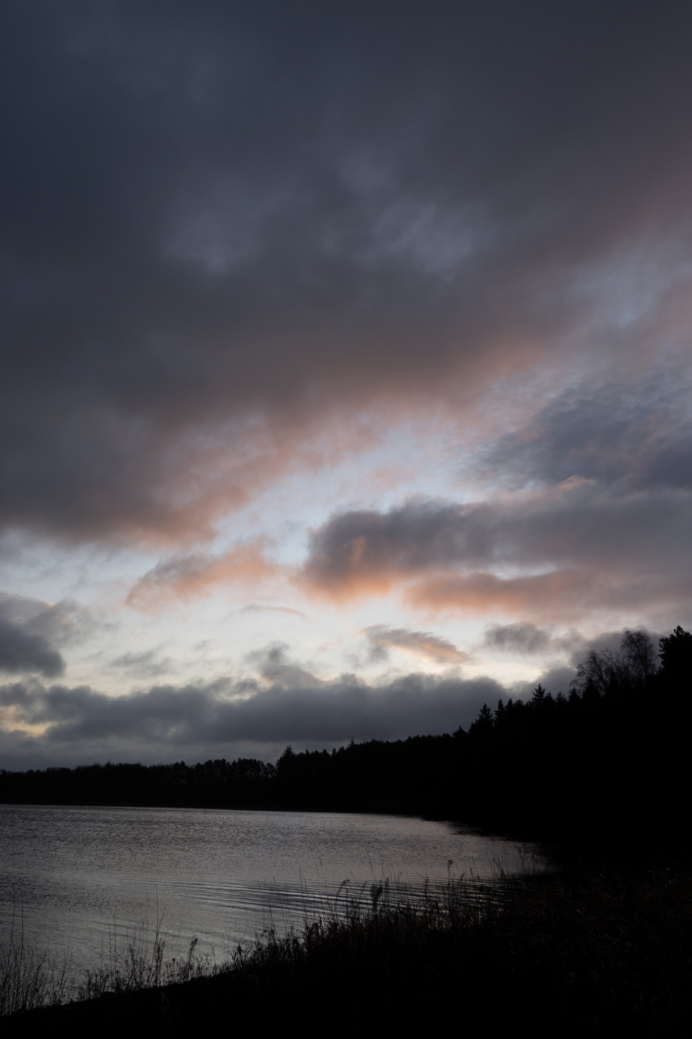  a group of clouds in the sky over a body of water