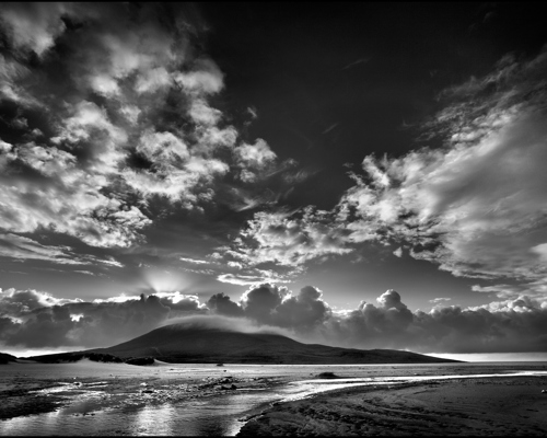 Seascapes of the Outer Hebrides:  a beach with a body of water and mountains in the background with Pearl Harbor in the background